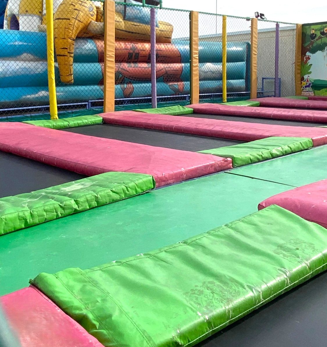 Camas elásticas Zonas de salto con colchones de colores en un parque de atracciones.