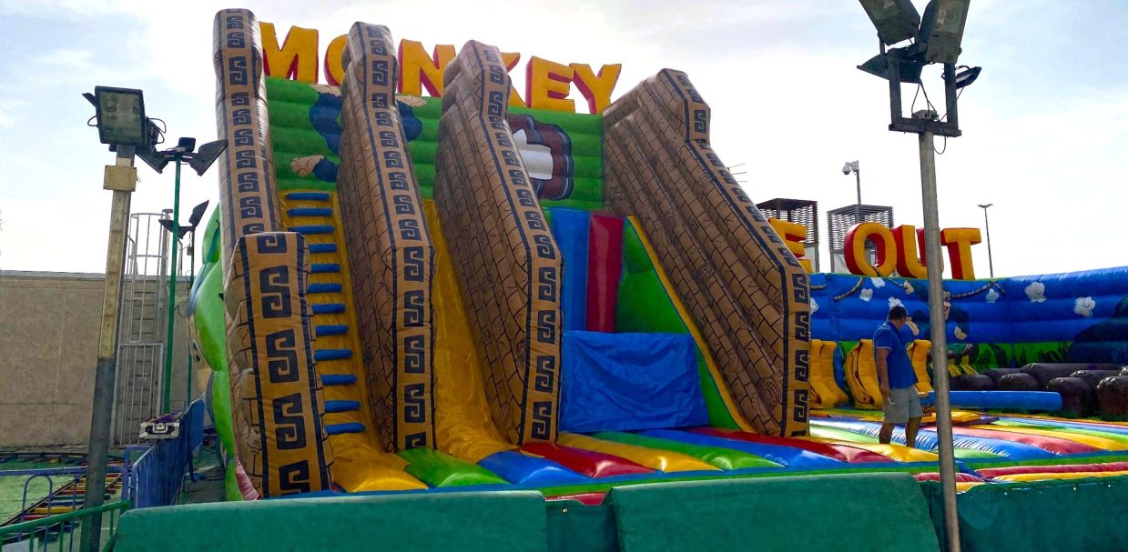 Tobogán y salto: solo para valientes Tobogán inflable de colores en un parque de diversiones, con figuras de monos.