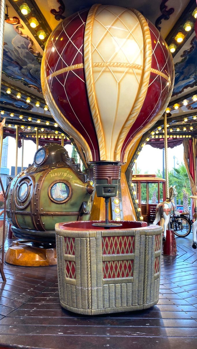 Globo aerostático Globo aerostático en un carrusel con detalles coloridos y una estructura metálica en el fondo.