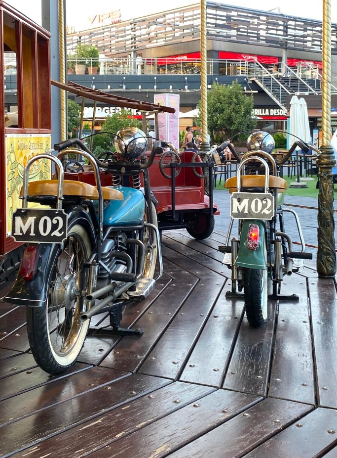 Motocicletas clásicas Dos motocicletas estacionadas en una plataforma de madera, con asientos de madera.
