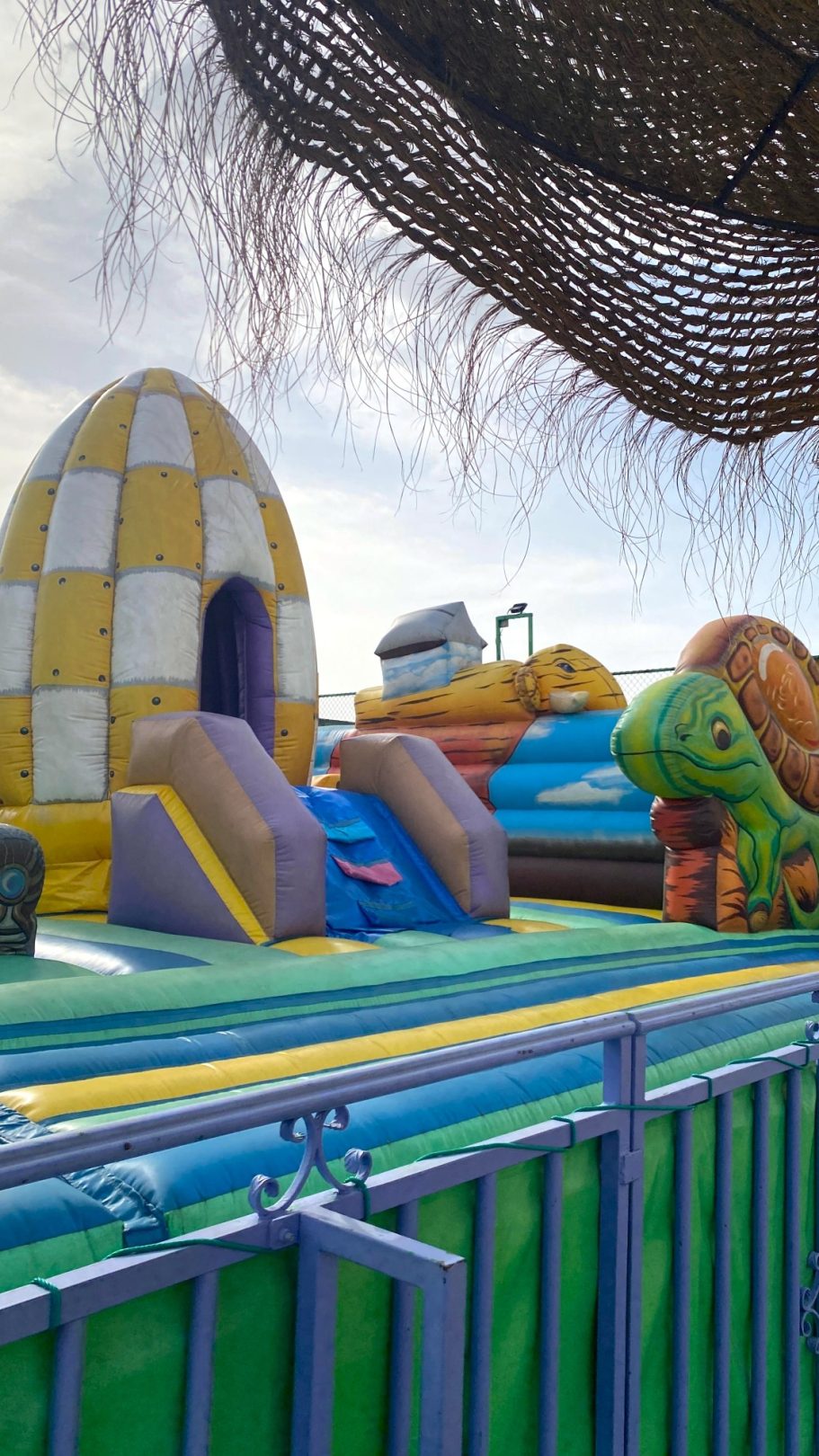 Diversión para los pequeños de la casa Inflables de colores en un parque de juegos al aire libre, con toboganes y figuras de animales.