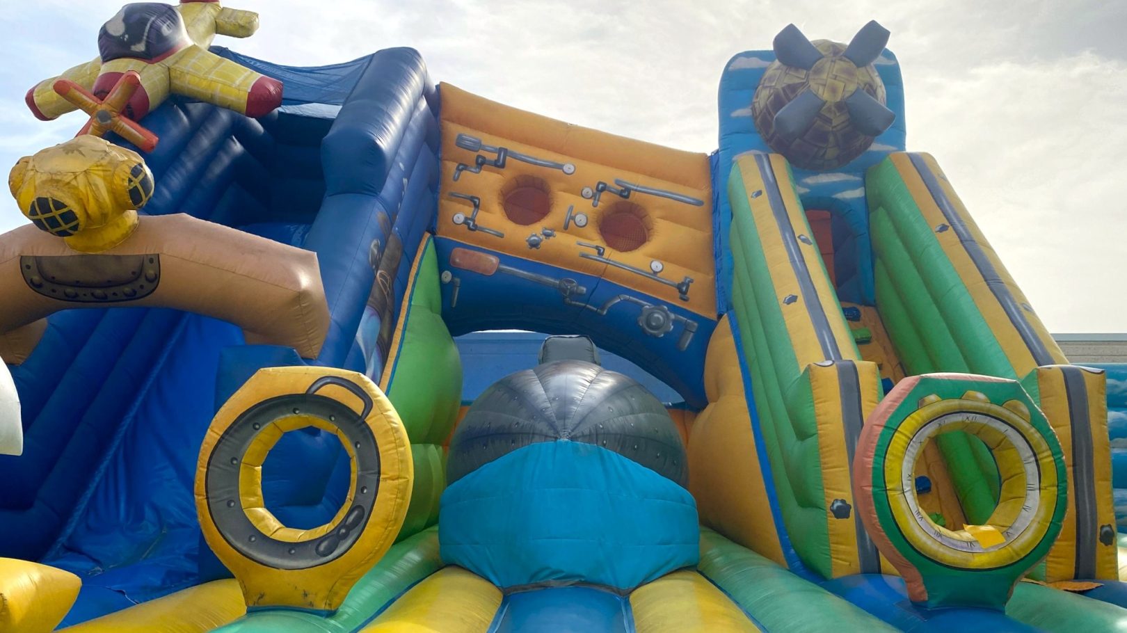 Puente con salto Tobogán inflable colorido con áreas para escalar y deslizarse.