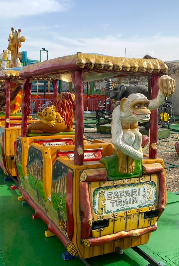 El mono: la guinda del pastel Tren de atracción decorado con animales y personajes coloridos en un parque de diversiones.