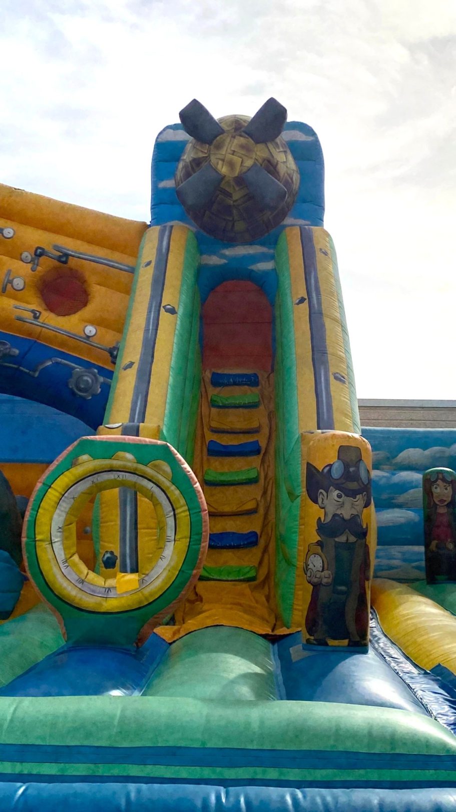 Escaleras del desafío Tobogán de un castillo inflable con un diseño colorido y una bola en la parte superior.