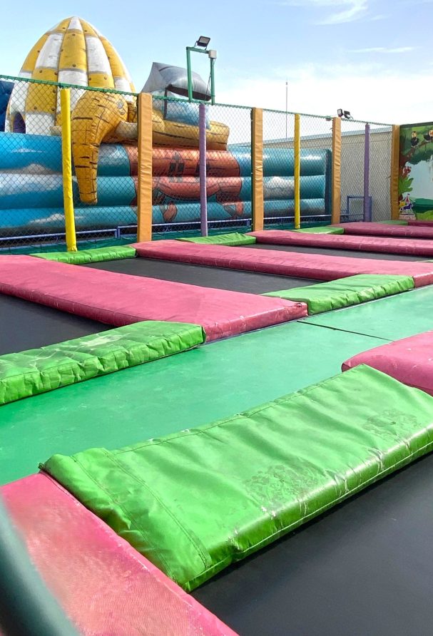 Camas elásticas Área de saltos con trampolines de colores en un parque de diversiones.