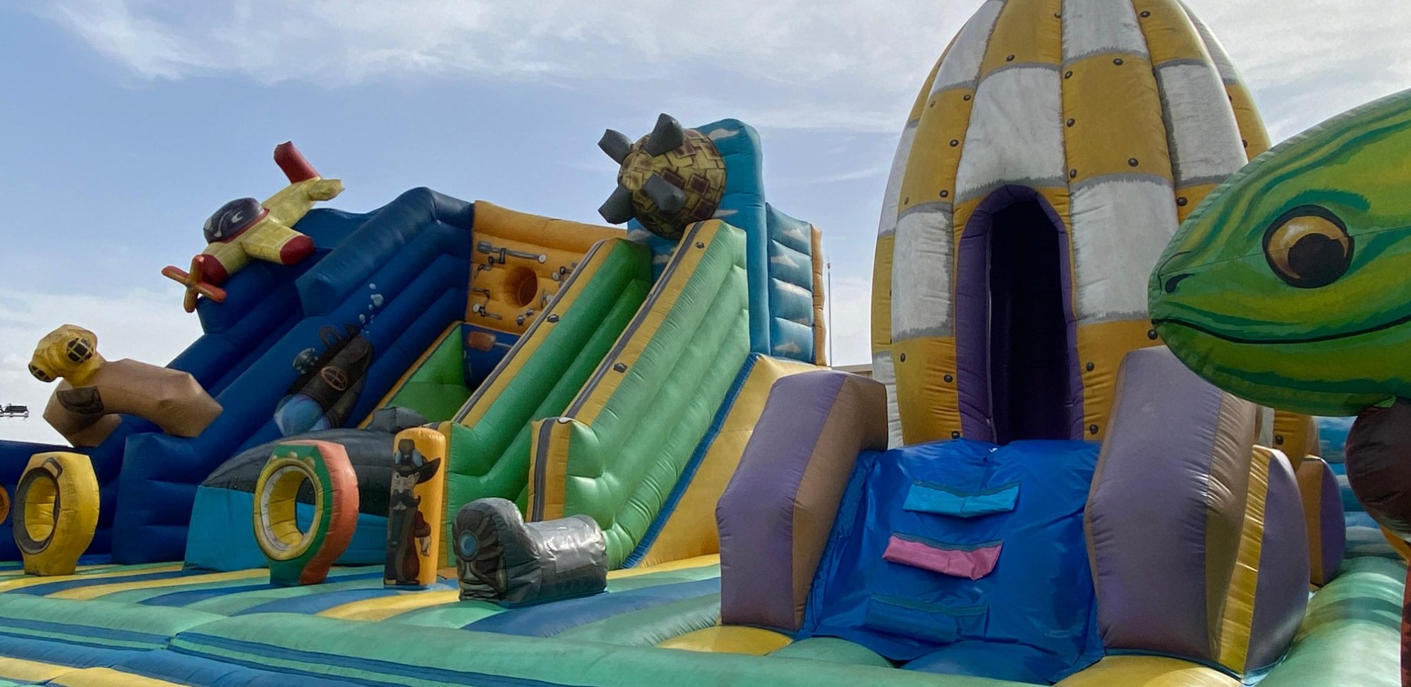 La selva encantada Inflables de colores con toboganes y figuras de animales en un parque de juegos.