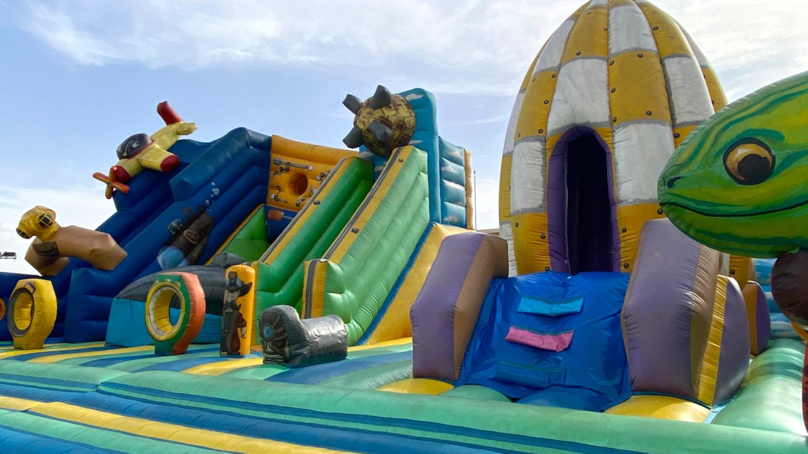 La selva encantada Inflable colorido con toboganes y figuras de animales en un ambiente de juego.