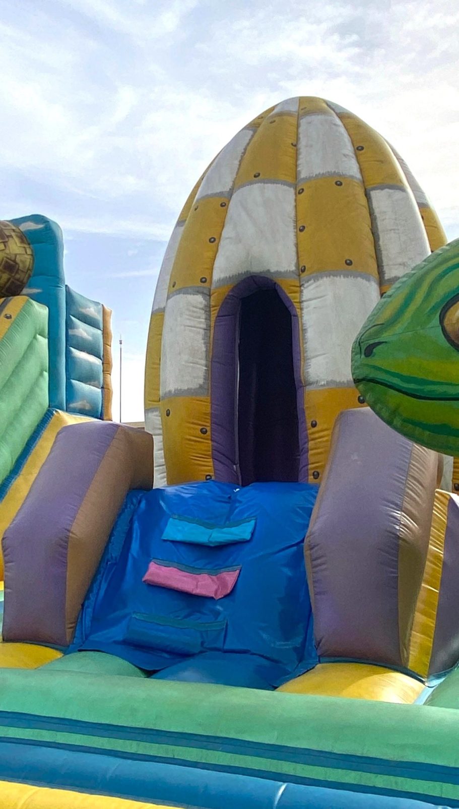 La nave espacial Castillo inflable colorido con tobogán y formas de animales.